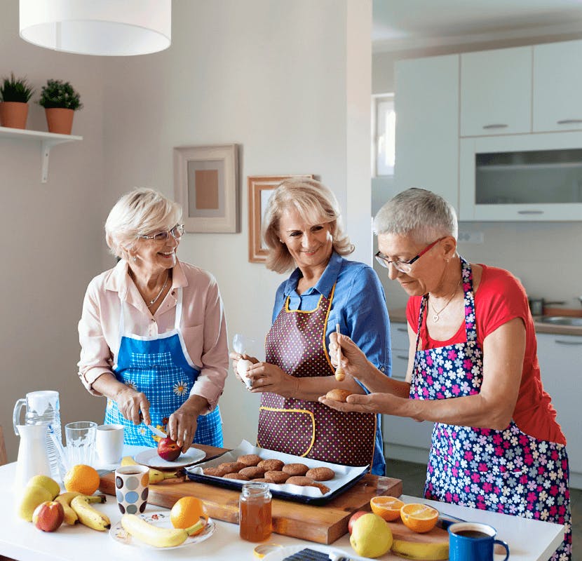 mujeres mayores cocinando juntas en un apartamento para mayores