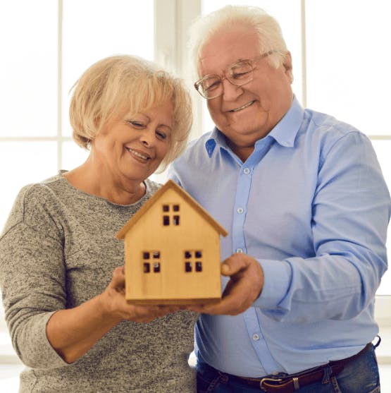 matrimonio sonriente sujetando una casa